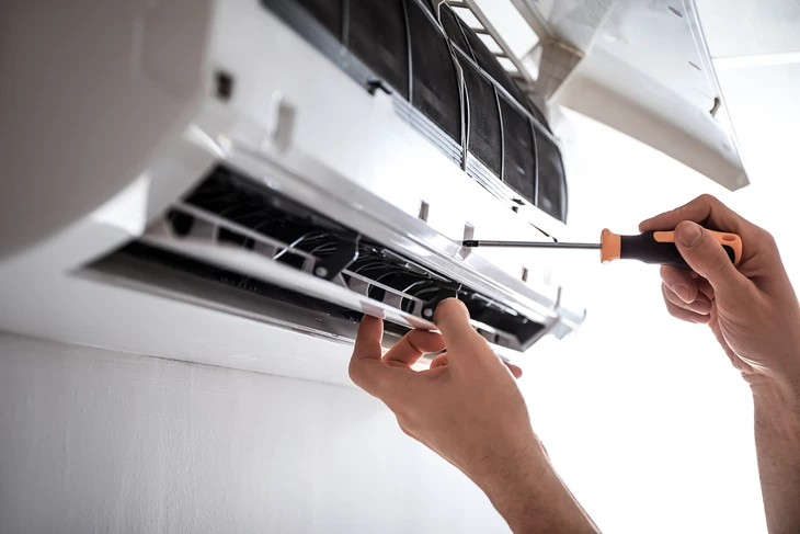 Homme utilisant un pistolet thermique infrarouge pour mesurer la température d'un mur intérieur jaune